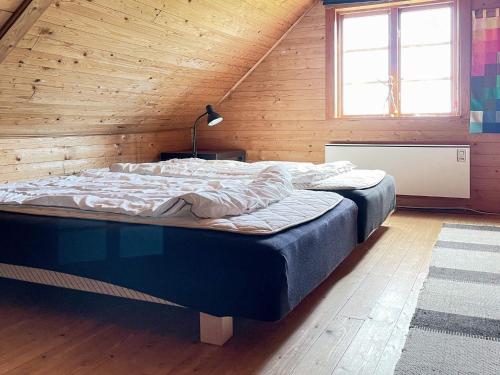 a bedroom with a large bed in a wooden room at 6 person holiday home in DEGEBERGA in Degeberga