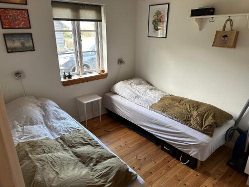 a bedroom with two beds and a window at Holiday home Kibæk in Kibæk