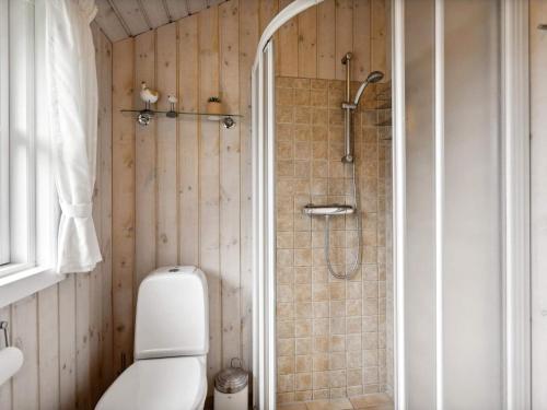 La salle de bains est pourvue d'une douche et de toilettes. dans l'établissement Holiday home Hemmet VI, à Hemmet