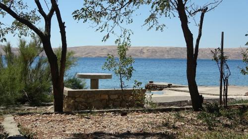 a picnic table in front of a body of water at Sweet house with garden 35 meters from sea in Karlobag