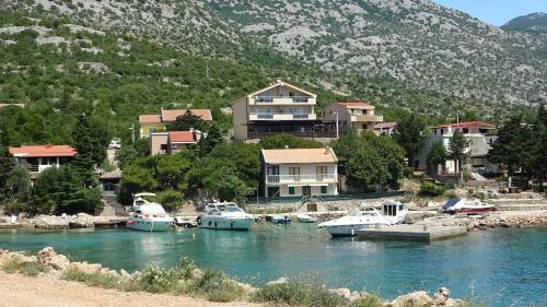 a group of boats docked in a river with houses at Sweet house with garden 35 meters from sea in Karlobag
