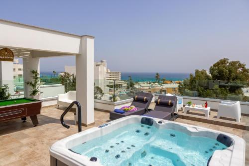 a hot tub on a balcony with a pool table at Fig Tree Bay Residences 4 in Protaras