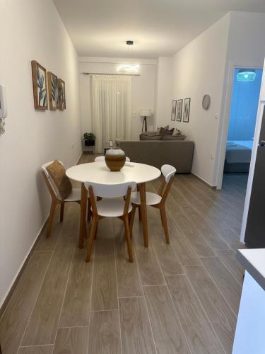- un salon avec une table et des chaises blanches dans l'établissement Iliana's apartment, à Karditsa
