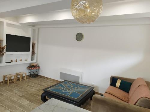 a living room with a couch and a table at Maison entre Dinan et Dinard in Pleslin-Trigavou