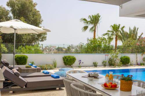 a patio with a table and chairs and a pool at Fig Tree Bay Residences 4 in Protaras