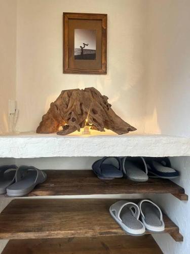 un estante con una pila de zapatos encima en 海と山と川、田園に囲まれた静かな古民家一棟貸し, en Miyazaki