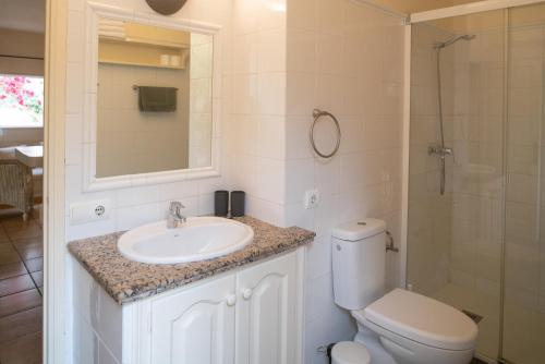 ein Bad mit einem WC, einem Waschbecken und einer Dusche in der Unterkunft Bungalows Casa Amarilla in Playa Migjorn