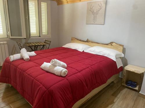 ein Schlafzimmer mit einem roten Bett mit Handtüchern darauf in der Unterkunft Bujtina Tinari Theth in Theth