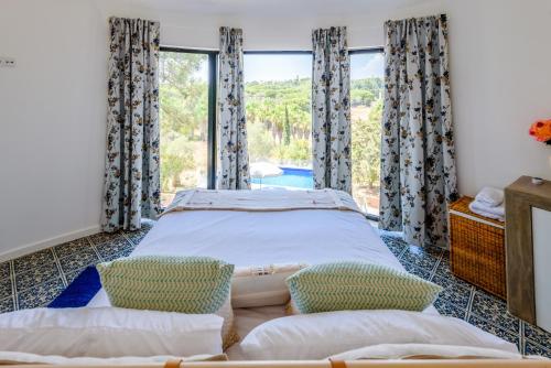 a bedroom with a bed and a large window at Casa dos Sonhos in Vale do Lobo