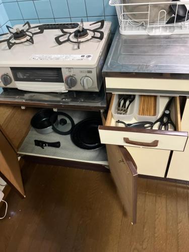 a kitchen with a stove and a counter top at メゾンジョイ久須志#205 in Aomori
