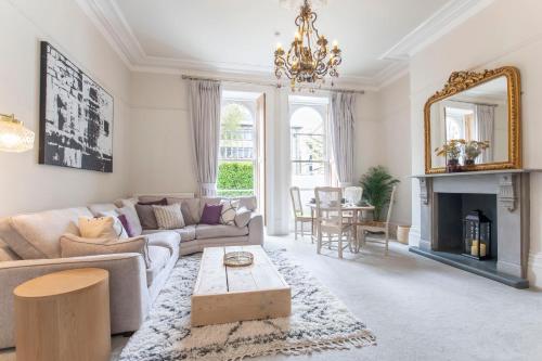 een woonkamer met een bank en een open haard bij St George's in Cheltenham