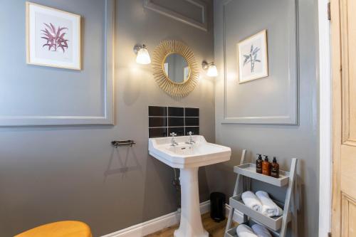 een badkamer met een wastafel en een spiegel bij St George's in Cheltenham