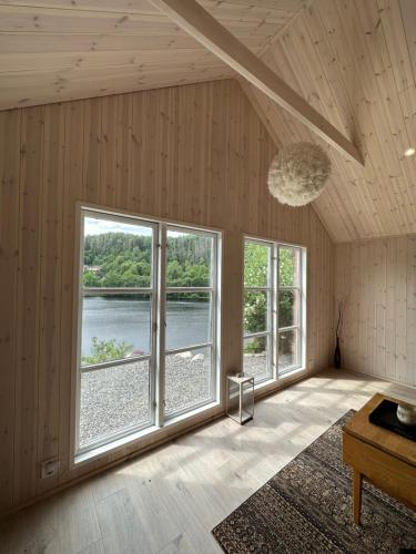 Habitación con ventanas grandes y vistas al lago. en Beautiful Barn Studio - Lake View en Porsgrunn