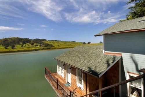 a house with a deck next to a body of water at 'Erinleigh By The Sea' Waterfront in Jenner