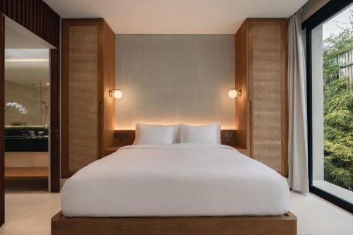 a large white bed in a room with a window at VOX Villas Canggu in Canggu