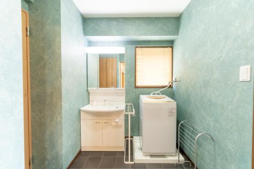 een badkamer met een wastafel en een toilet in een kamer bij Suite Room PayPayヤフオクドーム Darinホークス通り2F in Fukuoka