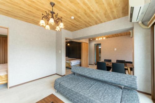 een woonkamer met een bank en een slaapkamer bij Suite Room PayPayヤフオクドーム Darinホークス通り2F in Fukuoka
