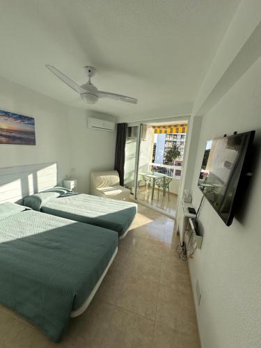 a bedroom with two beds and a flat screen tv at Tamarindo 5 in Benalmádena