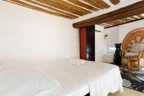 une chambre avec un lit blanc et une chaise dans l'établissement Incredible loft in Vieil Antibes with AC, à Antibes