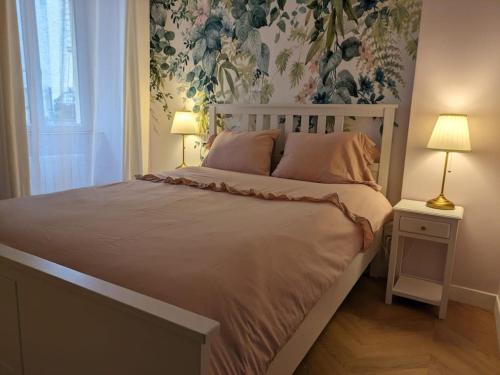 a bedroom with a large bed with a floral wallpaper at Appartement avec jardin et accès mer in Grandcamp-Maisy