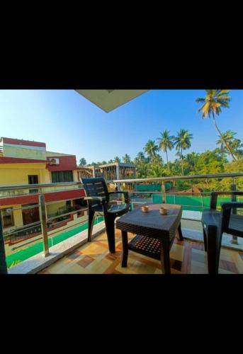 a table and chairs on a balcony with a view at Cornerpoint bungalows in Alibaug