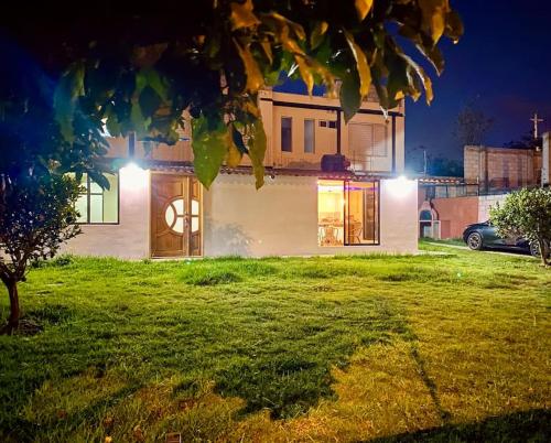 a house with lights on the front of it at Villa Mirlo – Escondite de Lujo en Quito in Quito
