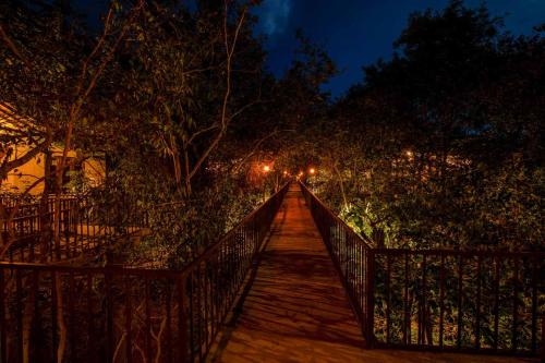 a wooden bridge over a forest at night at Sigiriya Forest Edge By Marino Leisure in Sigiriya