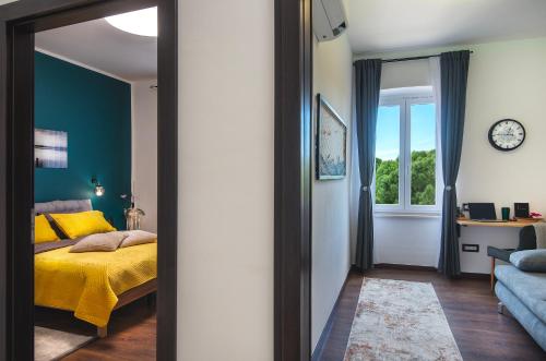 a bedroom with a yellow bed and a window at Lux Maximus in Pula