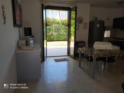 a kitchen with a table and a door to a yard at Villa Antonella in Noto Marina