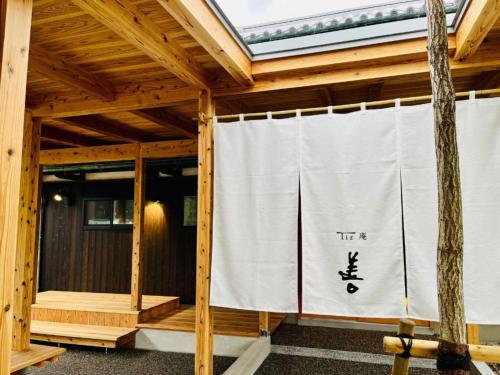 um alpendre com uma cortina branca em Tiz庵　善 em Minato