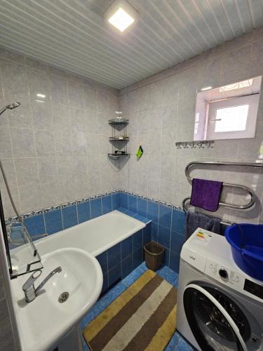 a bathroom with a tub and a sink and a washing machine at DIlfuza in Yunusobod