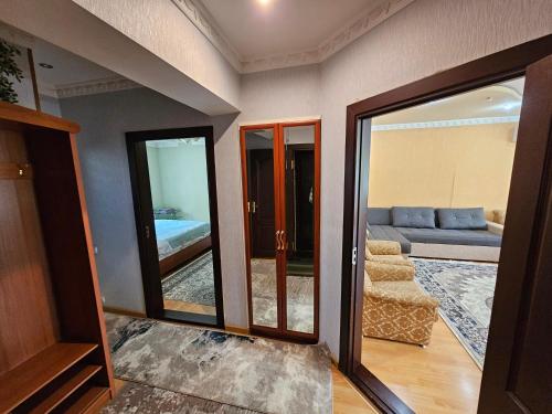 a living room with a couch and a mirror at DIlfuza in Yunusobod