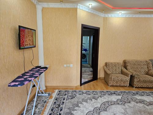 a living room with a table and a couch at DIlfuza in Yunusobod
