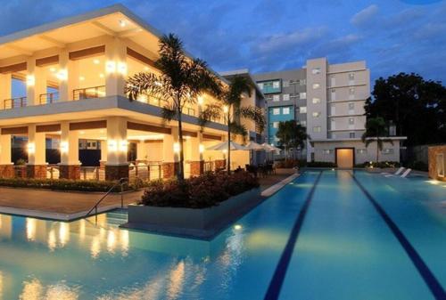 um edifício com piscina em frente a um edifício em Two Bedroom Condo Unit at 8 Spatial Davao em Davao