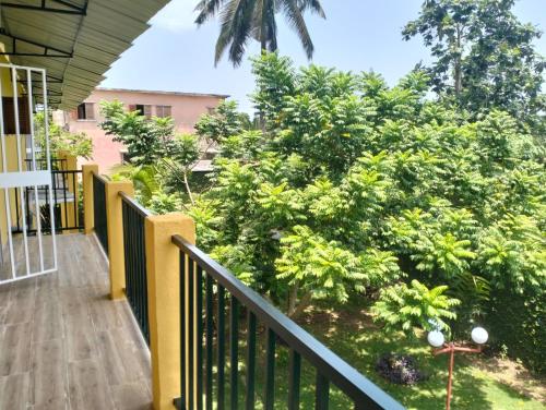 a balcony of a house with a tree at Moradia Turistica MJ ROOMS CITY in São Tomé
