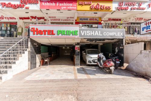 a hotel entrance with a car parked in front of it at Hotel Prime in Ahmedabad