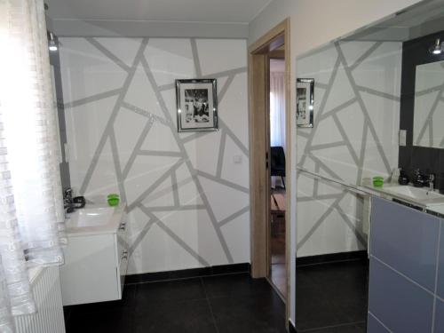 a bathroom with two sinks and a geometric wall at Holiday Home in Stepnica by Szczecin Lagoon in Stepnica