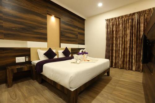 a bedroom with a large bed in a room at Hotel Milan Bijapur in Bijāpur