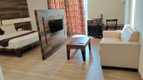 a living room with a couch and a coffee table at Hotel Milan Bijapur in Bijāpur