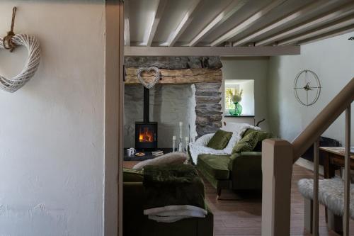a living room with a green couch and a fireplace at Pen-Y-Bryn Cottage in Blaenau-Ffestiniog