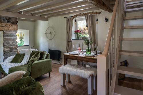 a living room with a table and a green couch at Pen-Y-Bryn Cottage in Blaenau-Ffestiniog