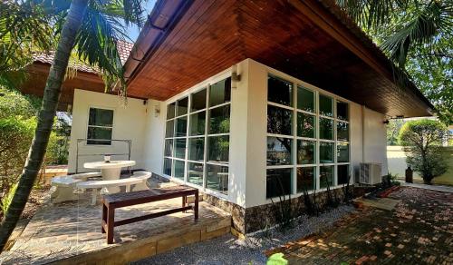 a screened in porch of a house with a bench at The Hillside Pranburi Resort in Pran Buri