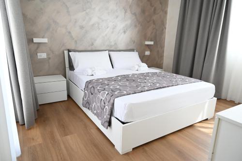 a bedroom with a white bed with white sheets at Perla Marina 2 Acitrezza in Acitrezza