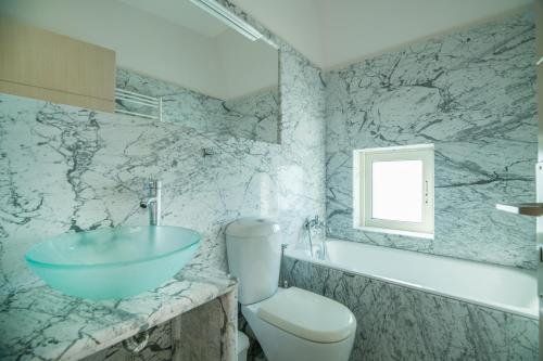 a bathroom with a bowl sink and a toilet at Sophia's Owl Flew Away Maisonette in Sitia