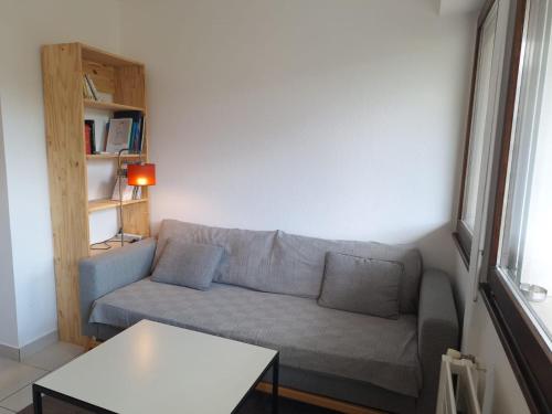 a living room with a couch and a table at Appartement au calme avec balcon proche Genève in Gaillard