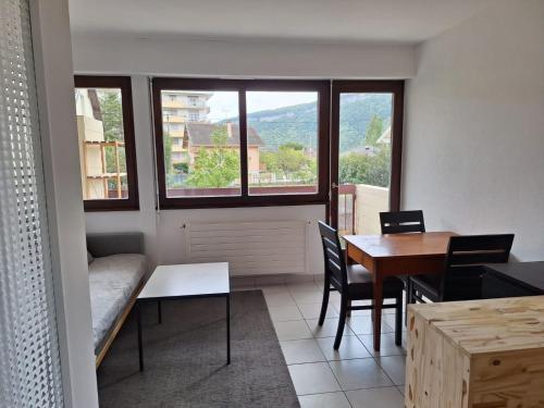 a living room with a table and chairs and a window at Appartement au calme avec balcon proche Genève in Gaillard