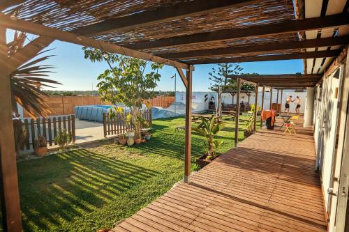 a wooden walkway leading to a yard with a house at Single Fin Conil in Conil de la Frontera