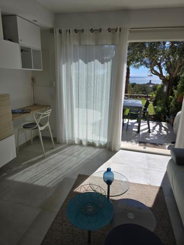 een woonkamer met een grote glazen schuifdeur naar een patio bij Perle d'or vue mer in Saint-Raphaël