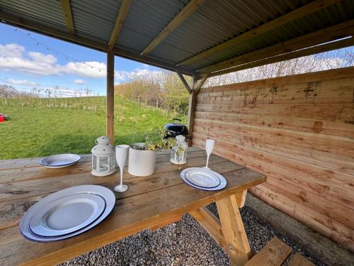 a wooden table with plates on top of it at Geodesic Dome Glamping in Llanidloes