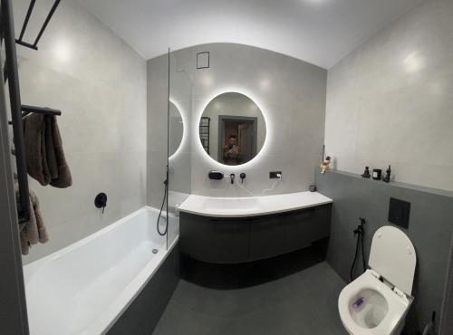 een badkamer met een bad, een toilet en een wastafel bij Комфортний люкс in Chmelnytsky